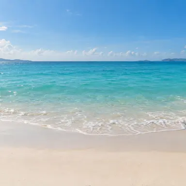 晴日海邊：海天與沙灘的橫幅場景，適合旅遊與休閒主題。
